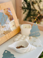 Coffret de Noël artisanal français avec accessoires décoratifs, bougie parfumée et coupelle coquillage effet terrazzo.