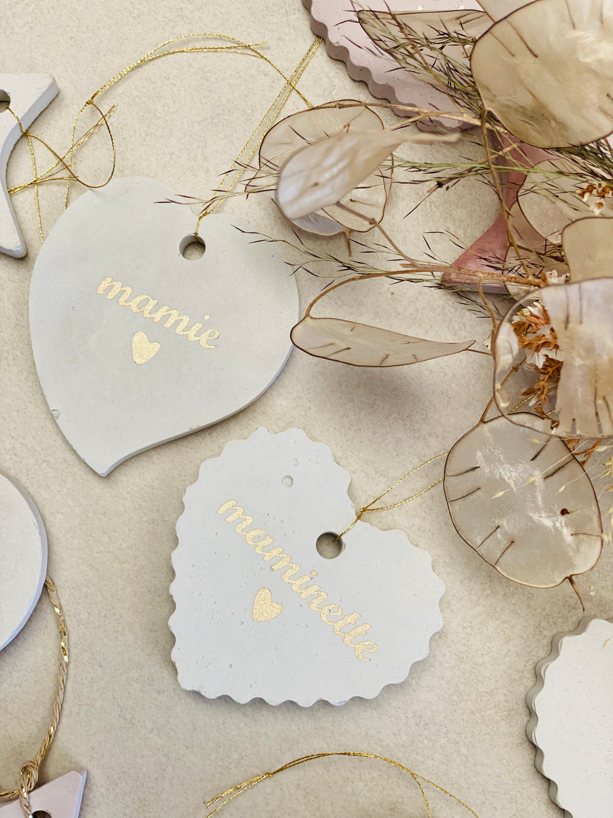 Deux suspensions en forme de cœurs blancs avec les mots personnalisés en vinyle doré pour mamie ou maminette 