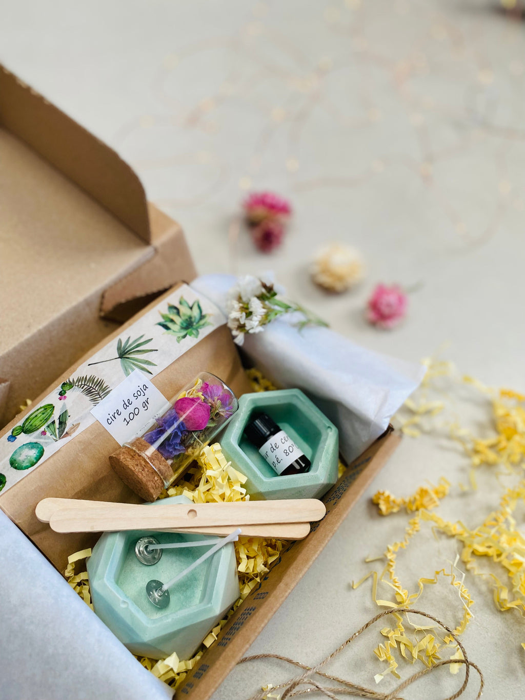 Kit DIY pour fabriquer des bougies florales, avec deux bougeoirs verts en béton, cire de soja, mèches en coton, fleurs séchées et accessoires de fabrication.
