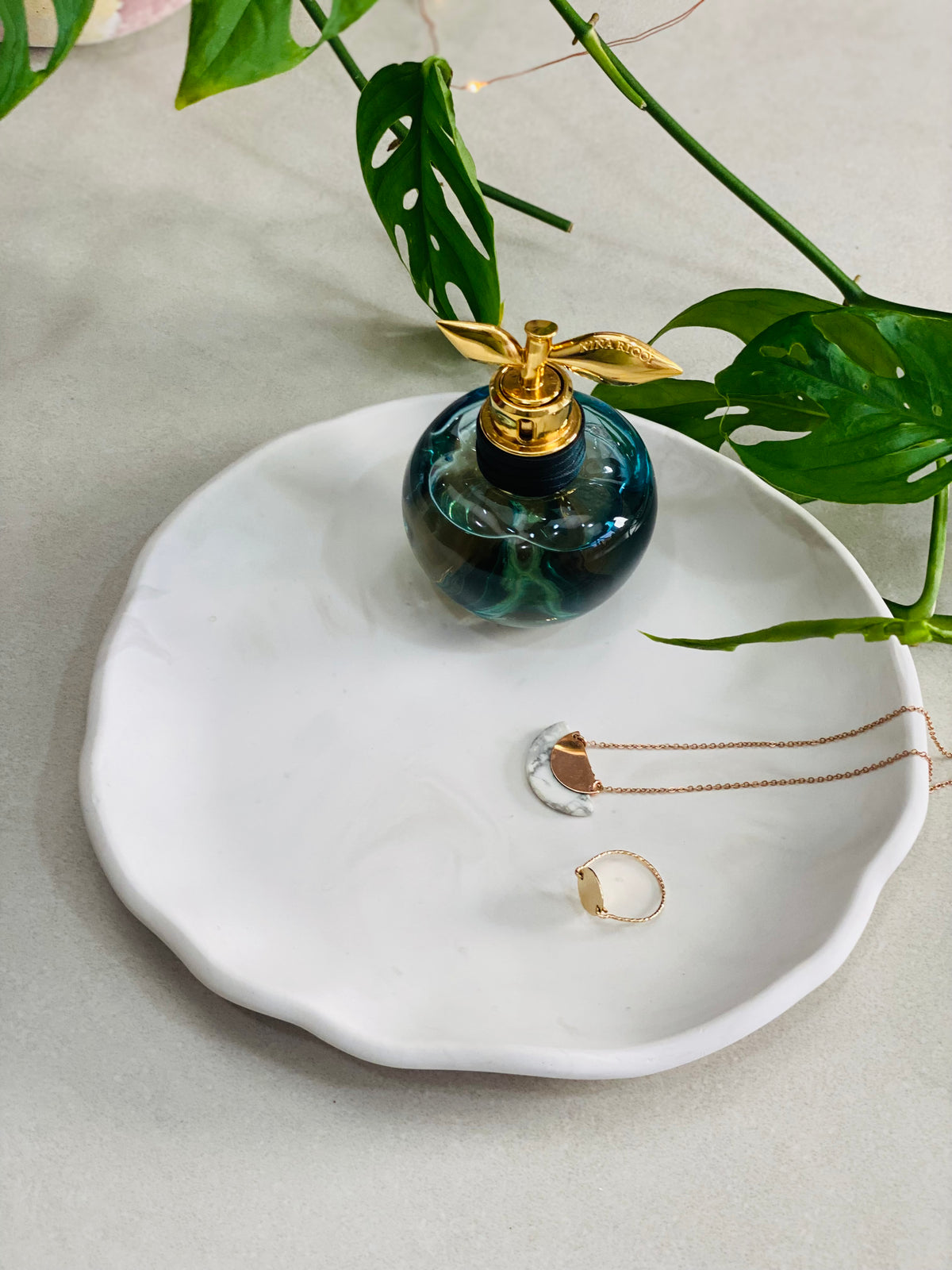 Plateau en Jesmonite blanc avec effet marbré gris pour présenter parfums et des bijoux