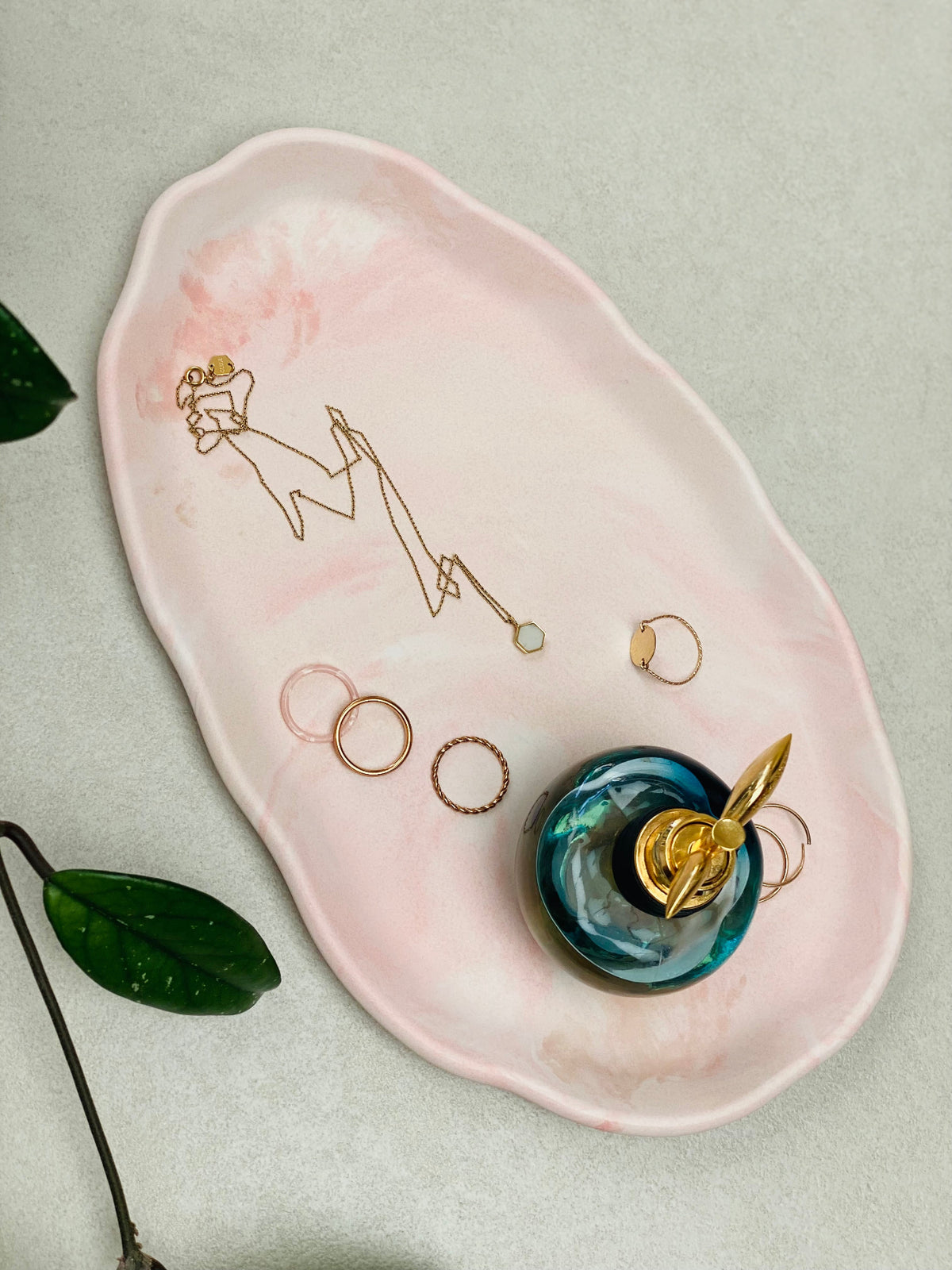 Plateau ovale irrégulier en Jesmonite marbrée rose pêche et avec un parfum et des bijoux 