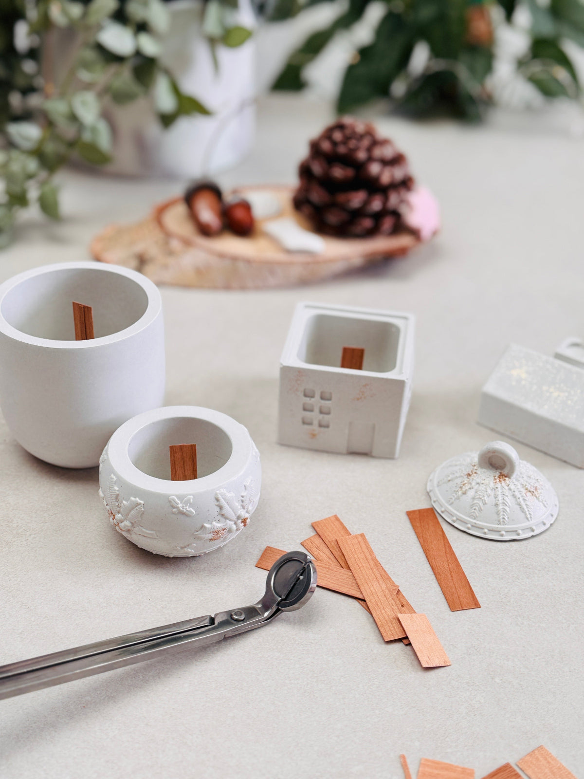 Bougeoirs blancs prêts à être coulés, avec leurs mèches en bois, dans une ambiance de Noël