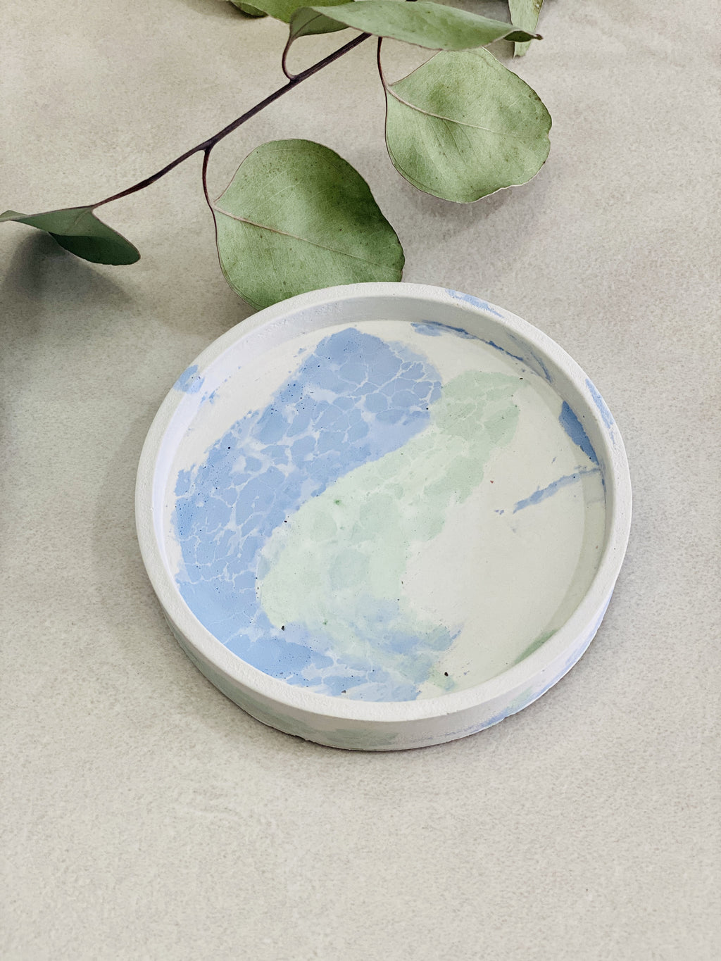 Support rond en béton motif craquelé coloris bleu vert 