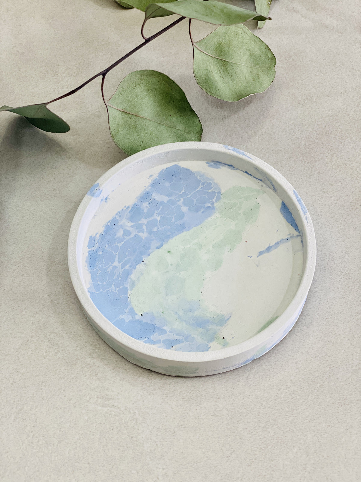 Support rond en béton motif craquelé coloris bleu vert 